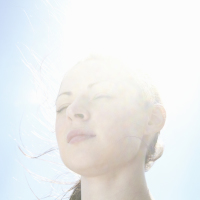 woman smiling with the sun right behind her