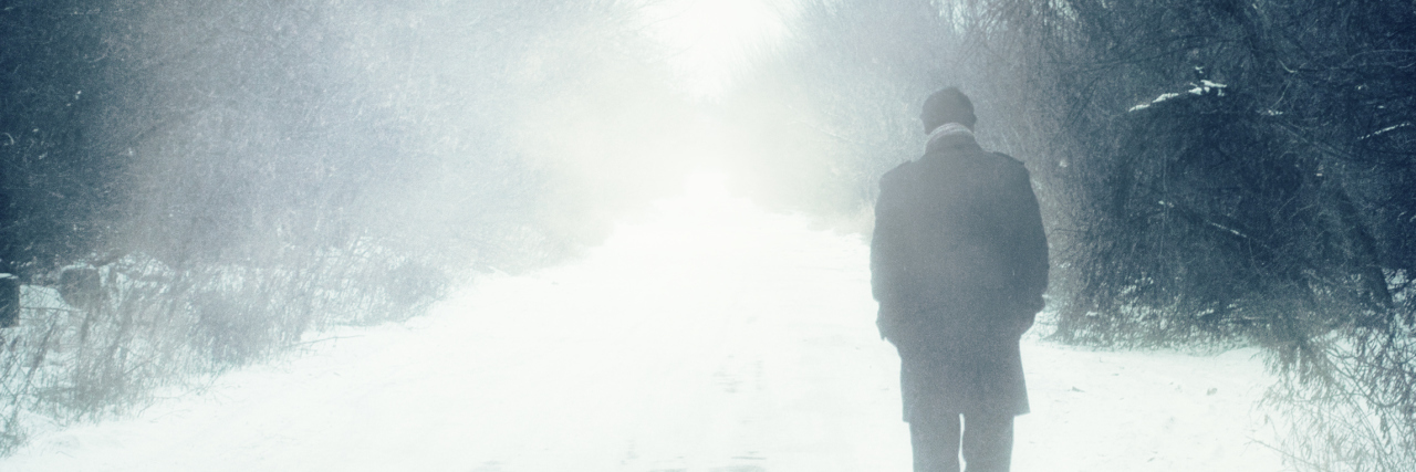When You're Dealing With Depression and Grief During the Holidays man walks alone in winter