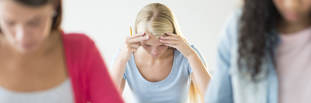 What It's Like Being an Ivy League Student With Lyme Disease A tired and frustrated looking student sitting at her desk.