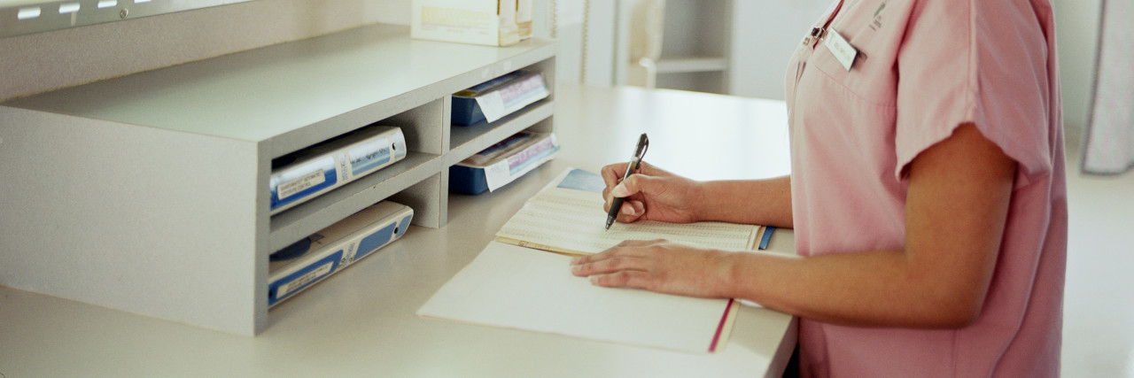 When an ER Nurse Was Condescending About My Chronic Pain nurse writing on paperwork in the x-ray examination room