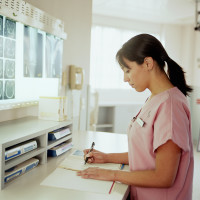 nurse writing on paperwork in the x-ray examination room
