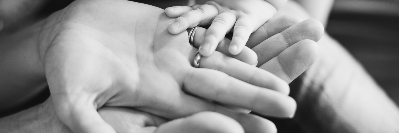 Finding Hope After Defeat and Preparing to Break Down Doors Closeup of baby's and parent's hands. black and white picture