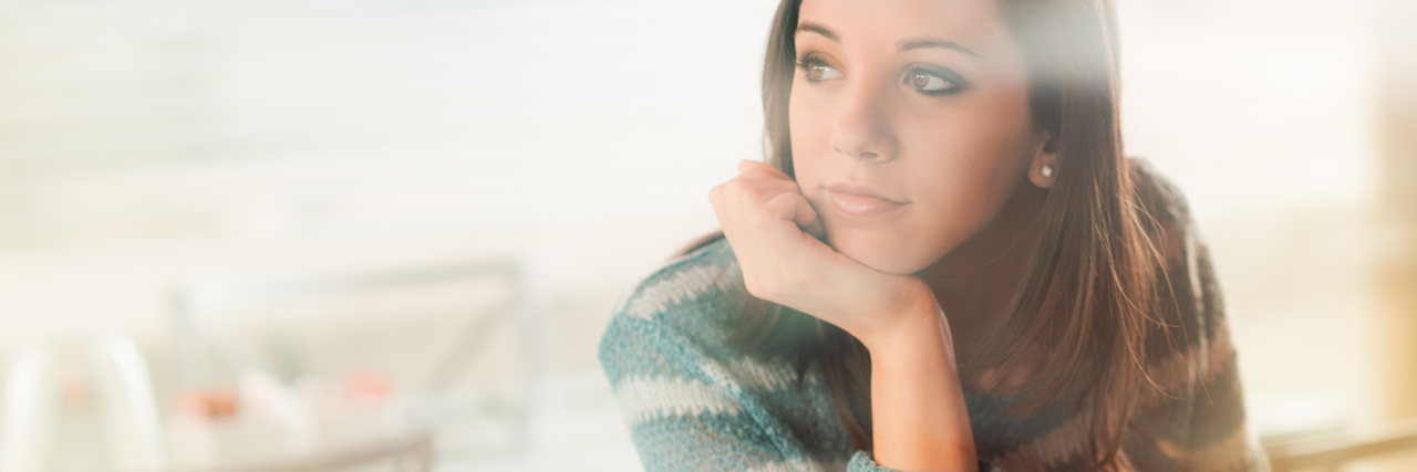 The Simple Statement That Gave Me Hope in My Struggle With OCD pensive woman sitting in front of laptop with hand on chin