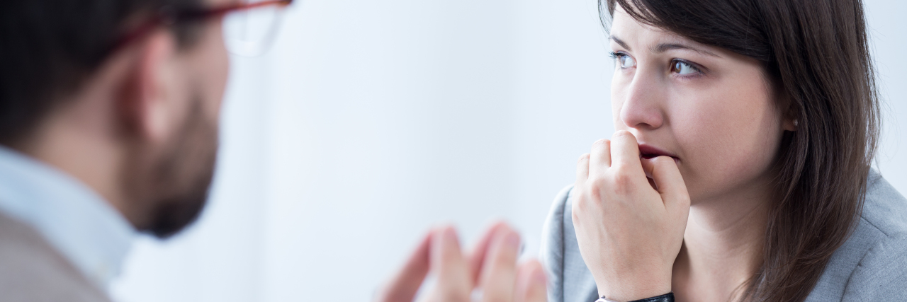 When Mental Health Professionals Say, 'Given Your History...' Image of stressed woman during meeting wuth personal coach