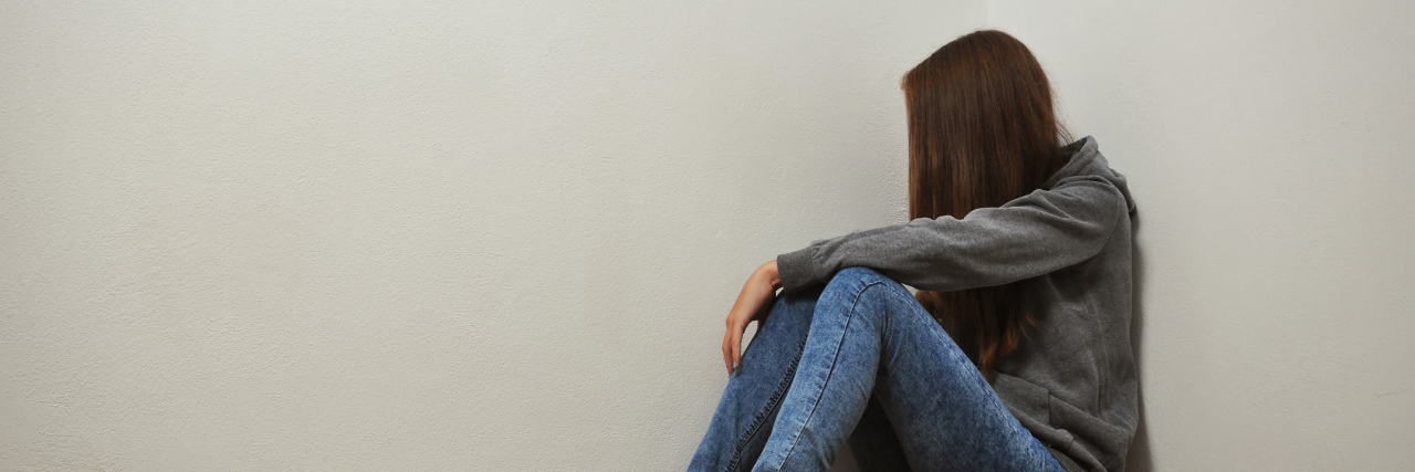 Why We Shouldn't Judge Someone Struggling With Self-Harm Young girl feeling lonely and crying in the corner.