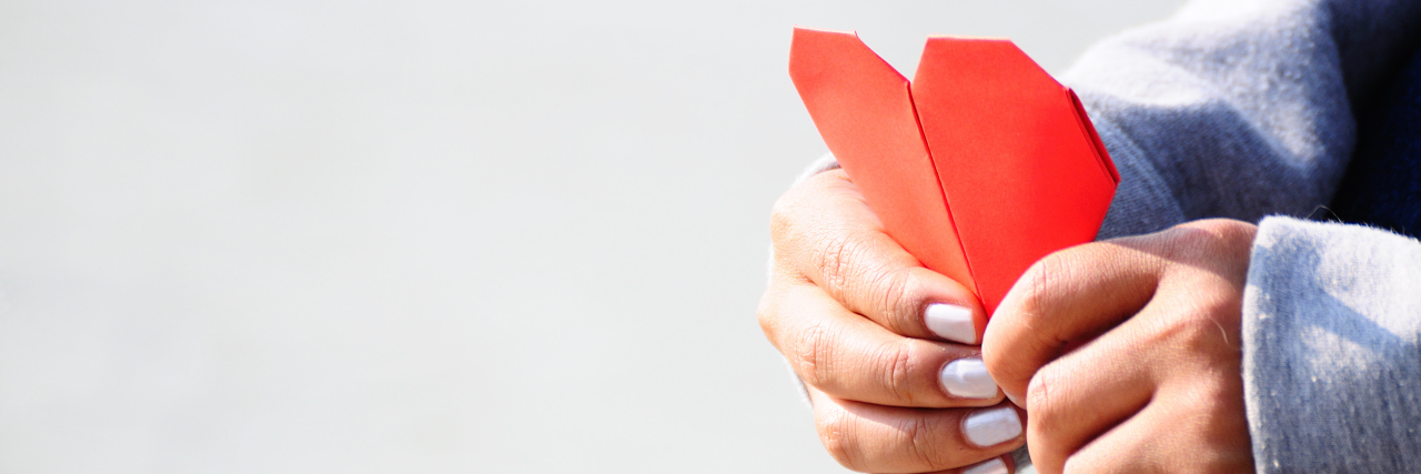 Hands Holding a Red Heart Shape Paper