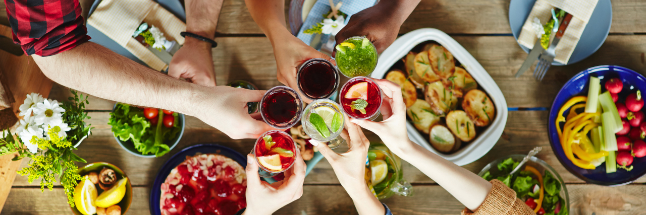 Accommodating a Traumatic Brain Injury Survivor at Parties Friends toasting at dinner table.