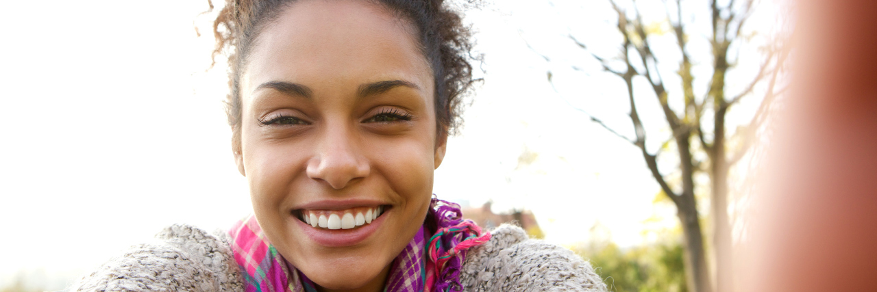When You Can't Control Your Illness A woman taking a selfie, smiling.