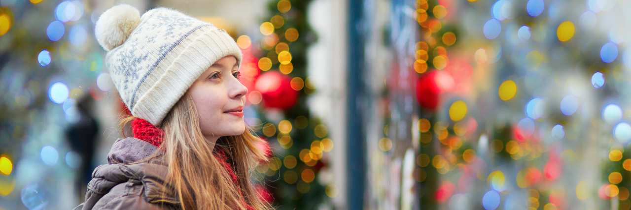 7 Tips for Navigating the Holidays During Eating Disorder Recovery Girl on a Parisian street or at Christmas market looking at shop windows decorated for Christmas