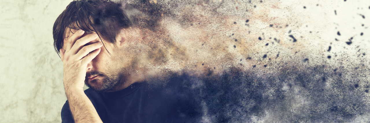 When My Chronic Pain Is Questioned by Others A man with his head in his hand, in pain, with a photoshop affect of a blur to his side.