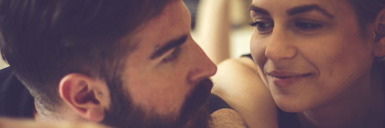 Navigating Intimacy and Relationships With Endometriosis woman and man smiling at each other in bed