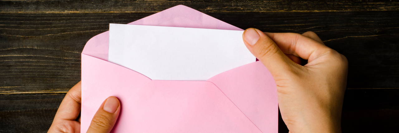 How 'Letters Against Depression' Helped My Depression Pink envelope and blank white card are hold by hand
