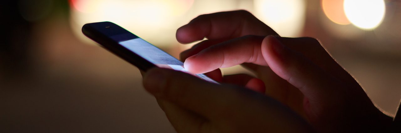 When I Reached Out to the Crisis Text Line About My Anxiety Attack close-up hand using phone in night time on street