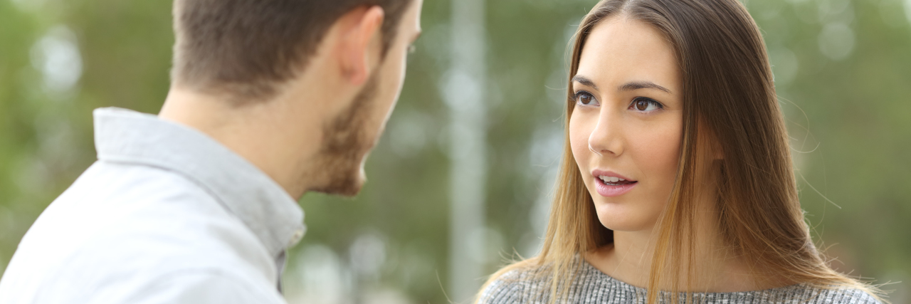 6 Things to Keep in Mind When Someone Asks About Your Self-Harm Scars Couple talking outdoors in a park with a green background