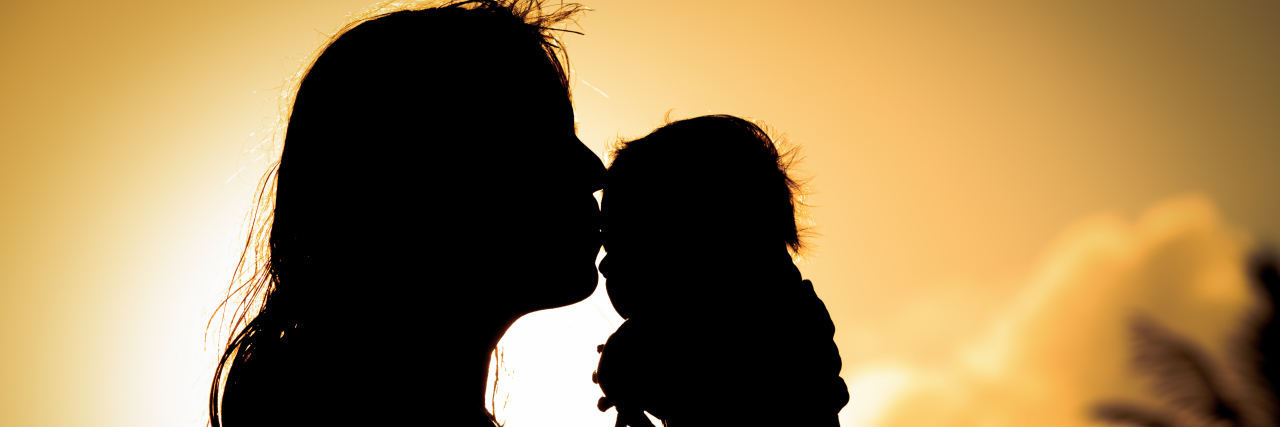 To My Daughter With Leukodystrophy on Your First Birthday loving mother and kissing little baby play at sunset