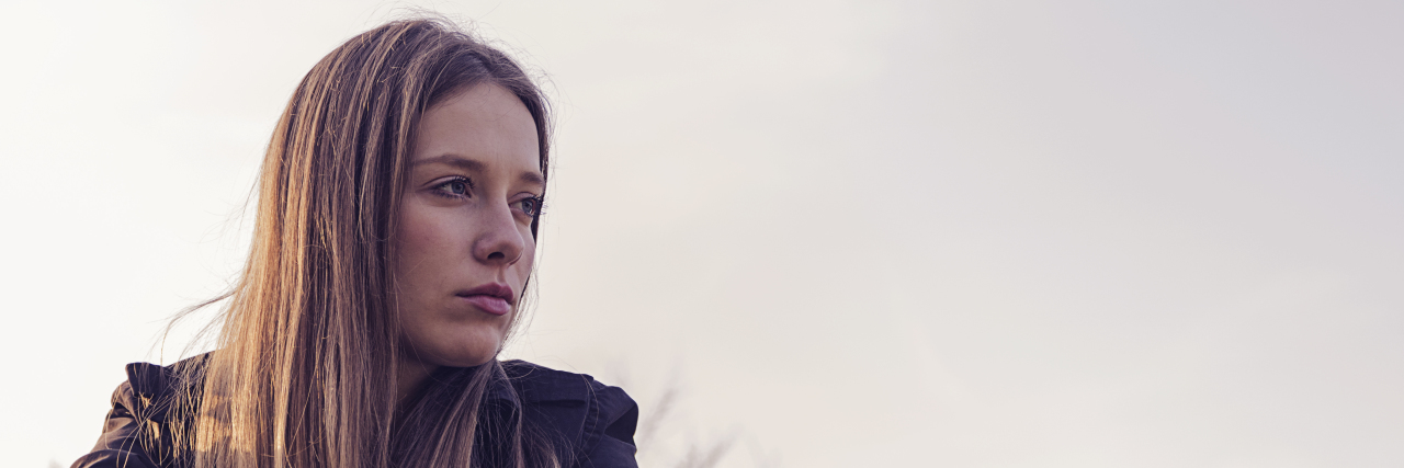 A sad and depressed alone outdoors. Outdoor portrait of a sad teenage girl. Lonely woman in despair