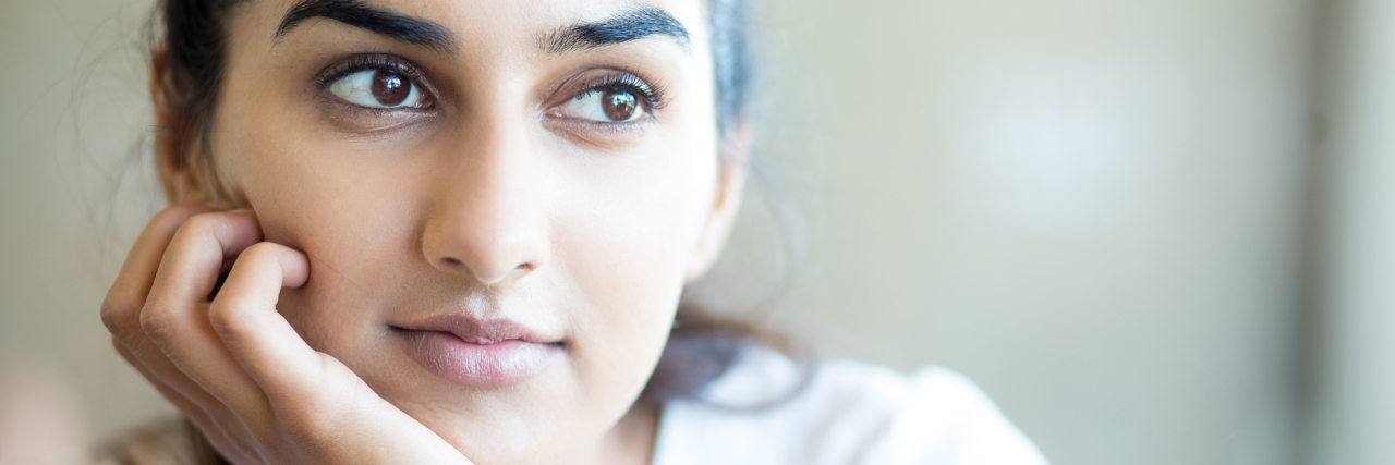 Don't Label Me as a 'Negative Person' If I Complain About My Illness A woman looking up with hopeful eyes.