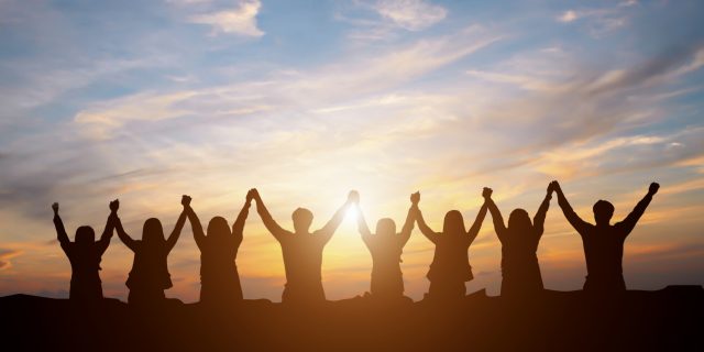 Sharing Our Victories as Members of the Stomach Cancer Community Silhouette of happy business team making high hands in sunset sky background for business teamwork concept