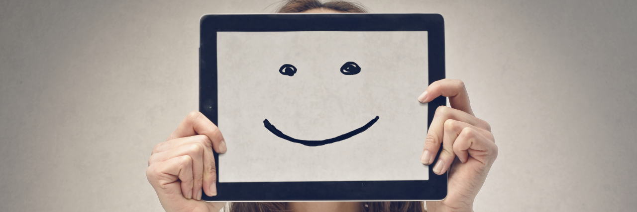 When You Hide Your Dissociation Behind Empty Smiles Woman shows with her tablet, that she is happy
