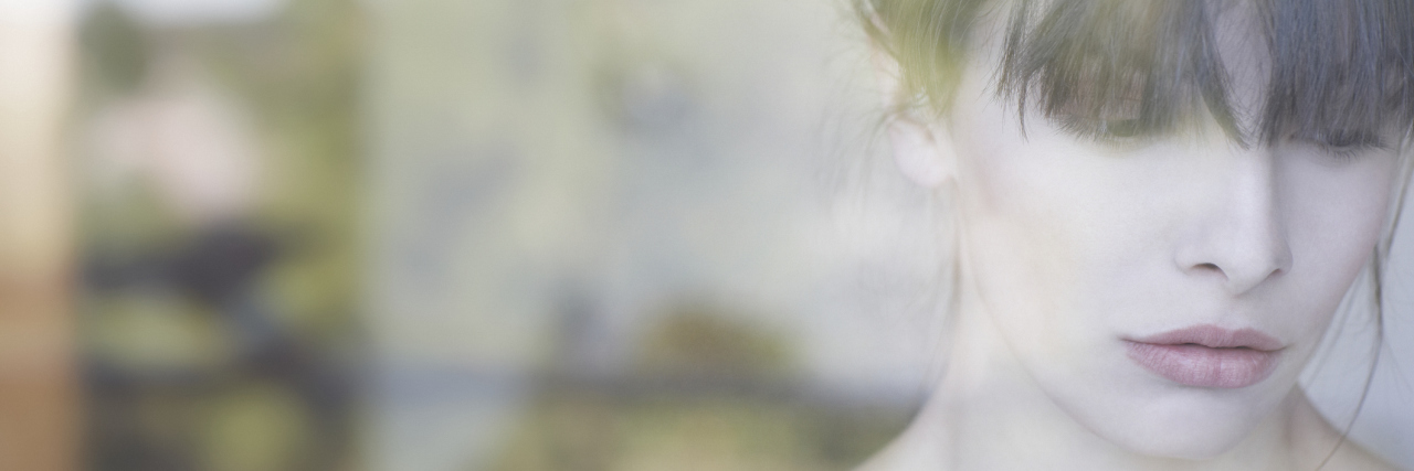 When You Have No Say Because of Interstitial Cystitis A shot of a woman through the window, with a sad expression looking to the ground.