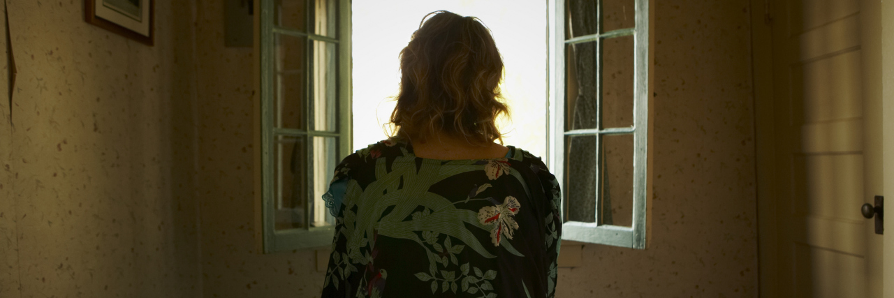 When Agoraphobia Keeps You From Living woman sitting on bed looking out of window silhouette