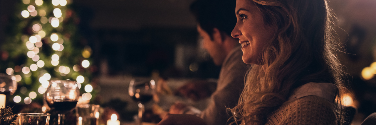 How I'm Preparing for Thanksgiving in Eating Disorder Recovery Beautiful young woman sitting with family and having christmas dinner. Family celebrating christmas together at home.