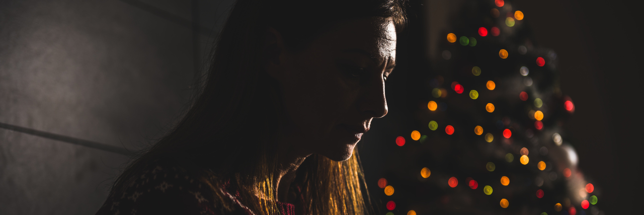 How I Survive the Holiday Season With Bipolar Disorder Lonely women sitting on the the sofa at home during christmas