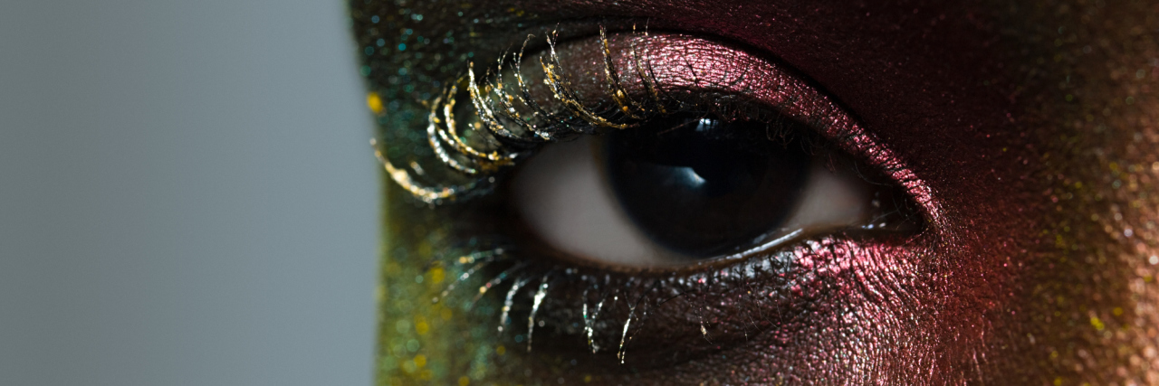 How to Come to Terms With the Limitations of Your Illness A close-up of an African American woman's eye, while she is wearing glitter makeup.
