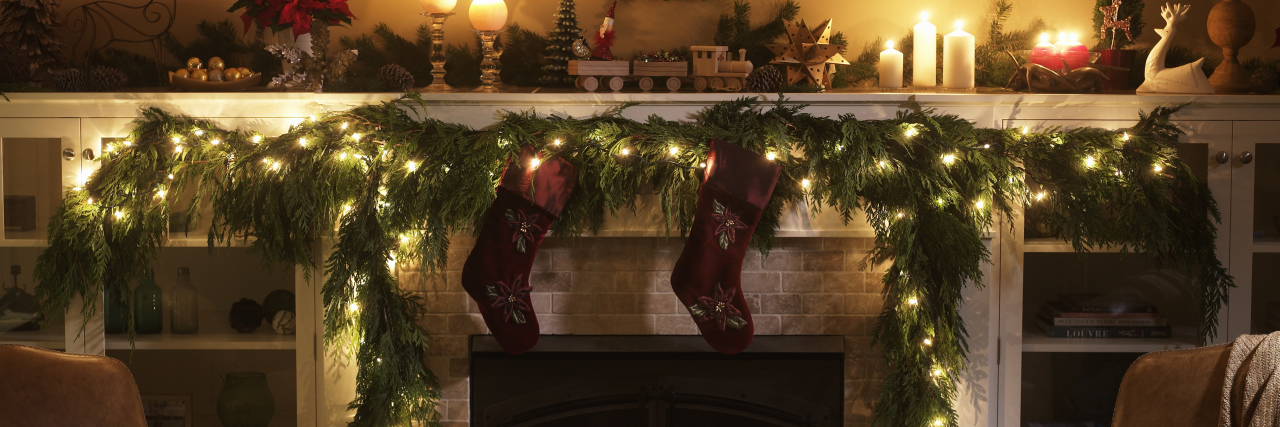 fireplace decorated with stockings and a wreath for christmas