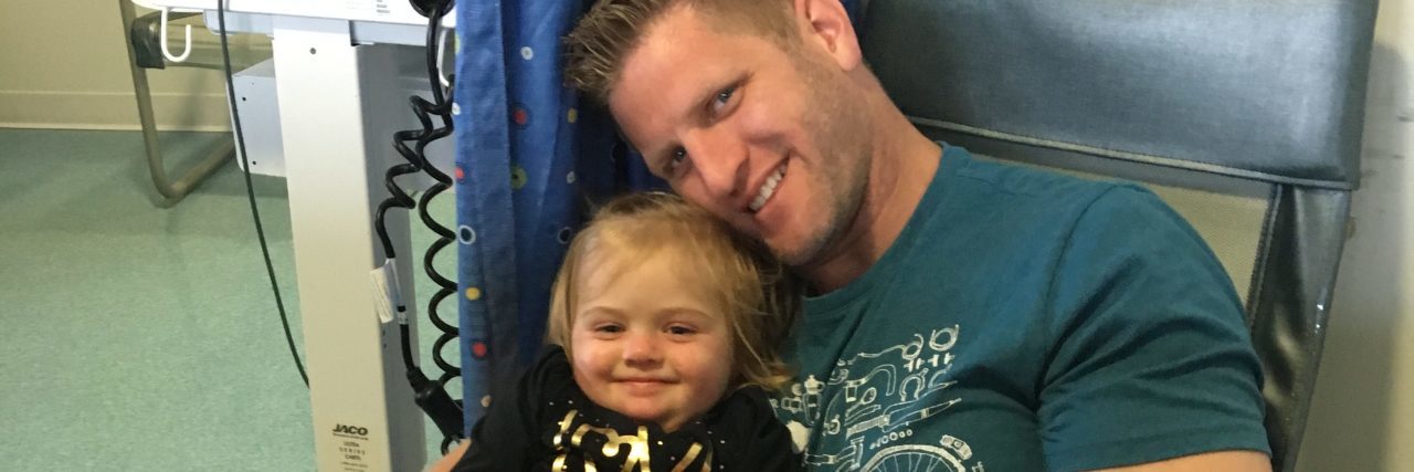 Father holding little girl at hospital