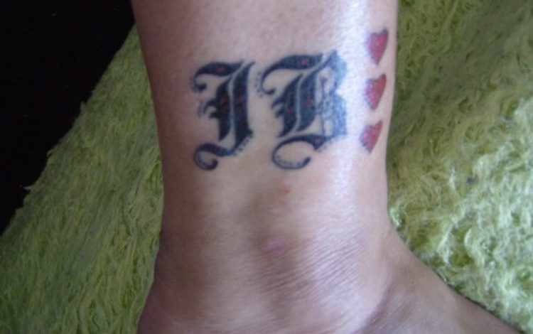 tattoo of initials and three hearts on wrist