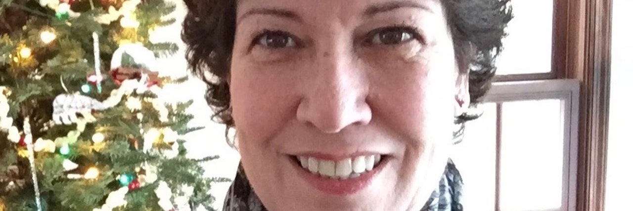 Why I'm Thankful for My Ileostomy woman with short dark hair taking a selfie in front of a christmas tree