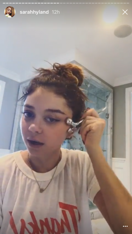 sarah hyland massaging her face with a facial massage roller