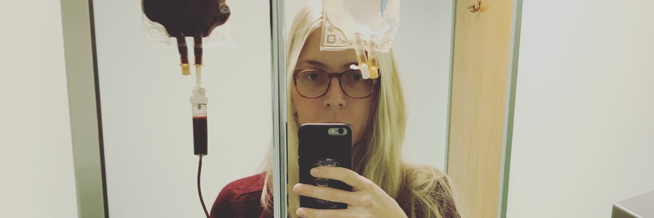 Why I Don't Like Being Labeled as a Person With Lyme Disease woman taking a selfie while receiving a blood transfusion