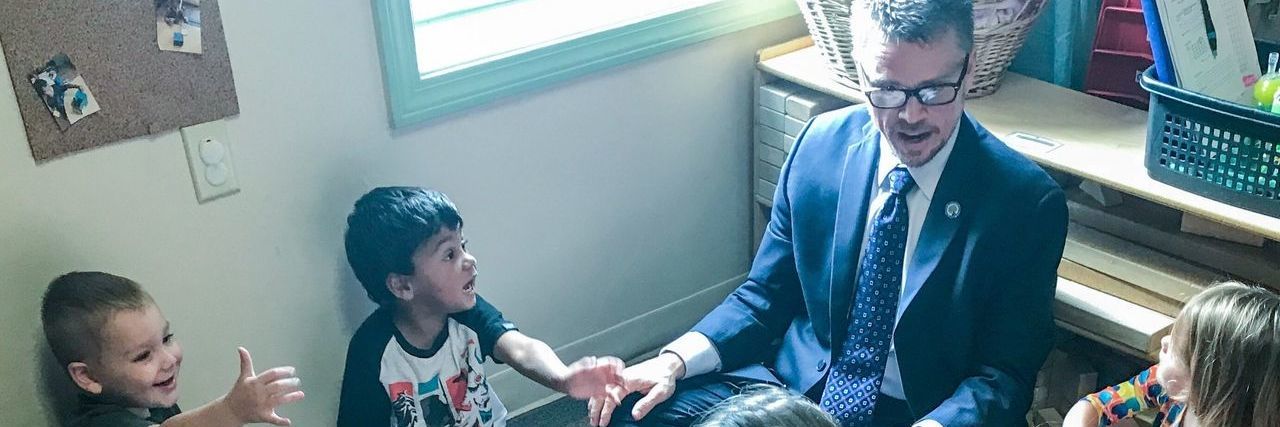 Trump to Nominate Johnny Collett for Special Education Position Johnny Collett sitting with a group of children