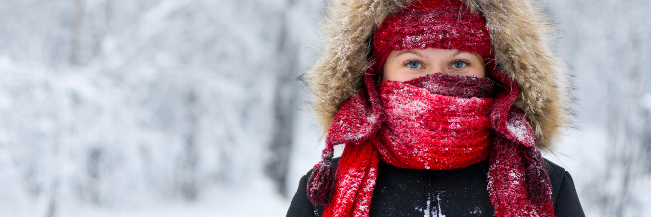 When Winter Depression Leaves You With No Motivation woman stands with scarf and hood over face during the winter