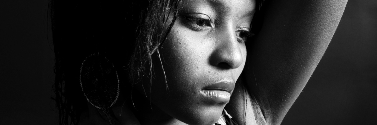 Why My Anxiety Made Me Hide in My Closet young woman in black and white looking upset against dark background