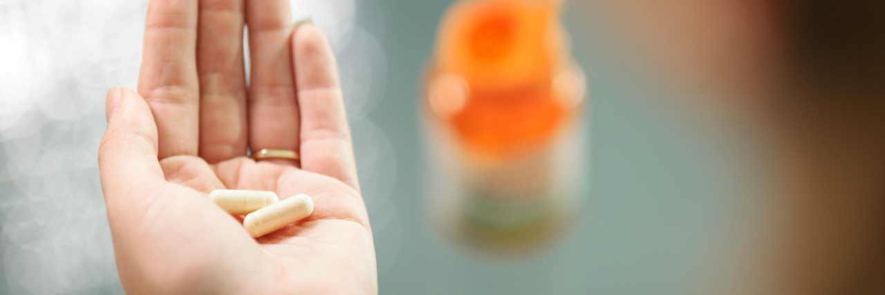 The Fear of Trying a New Medication for Insomnia woman holding pills in her hand