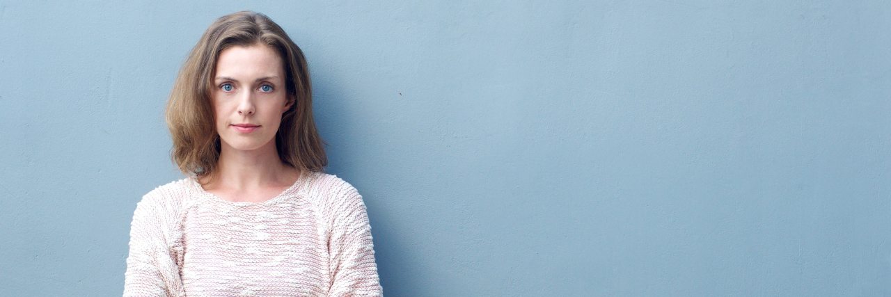 Why Epilepsy Needs More Awareness and Coverage by the Media woman standing against a wall with her arms crossed