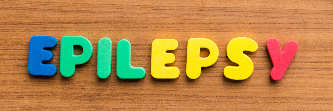 My Childhood Epilepsy Experiences Epilepsy colorful word on a wooden background.