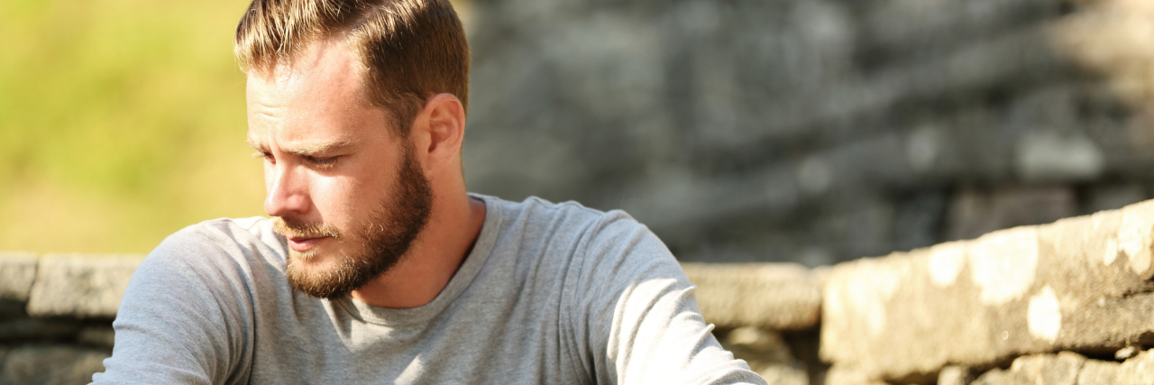 Seeking a Diagnosis and Treatment for Autonomic Neuropathy man sitting outside looking down