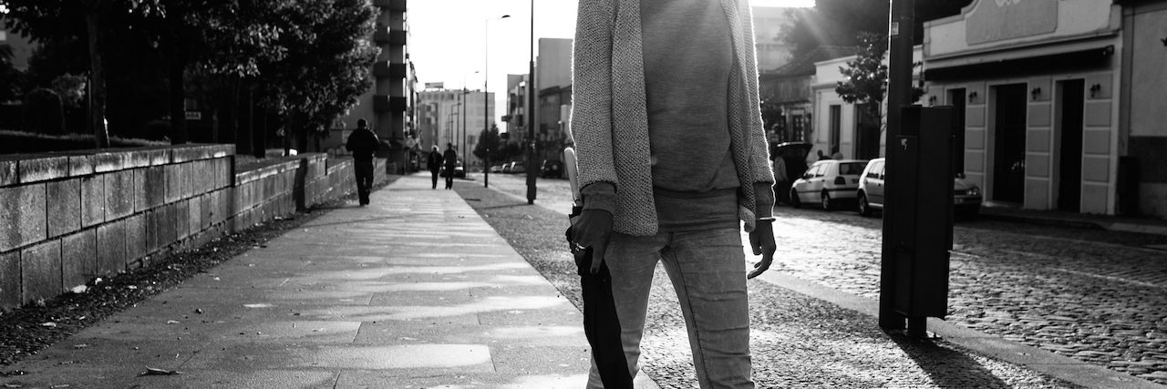 How Catcalling Affects My Mental Health Woman with umbrella walking on the rain in old town