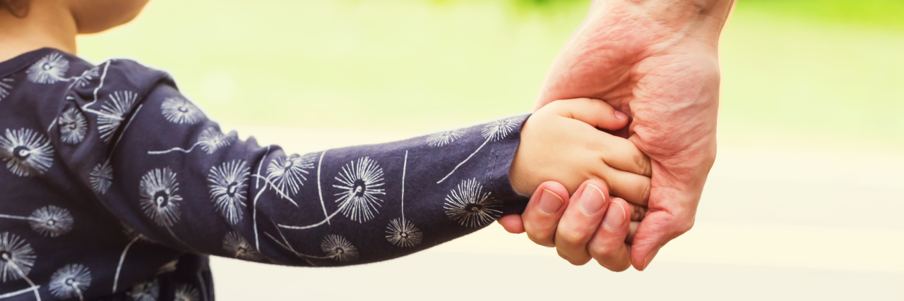 How I'm Parenting With Post-Traumatic Stress Disorder Toddler girl holding hands with her father outside