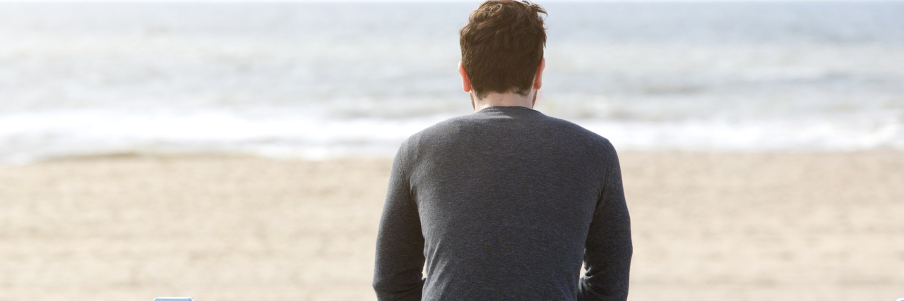 The Emotions of My Grief Are Valid Man looking at the ocean in front of the beach