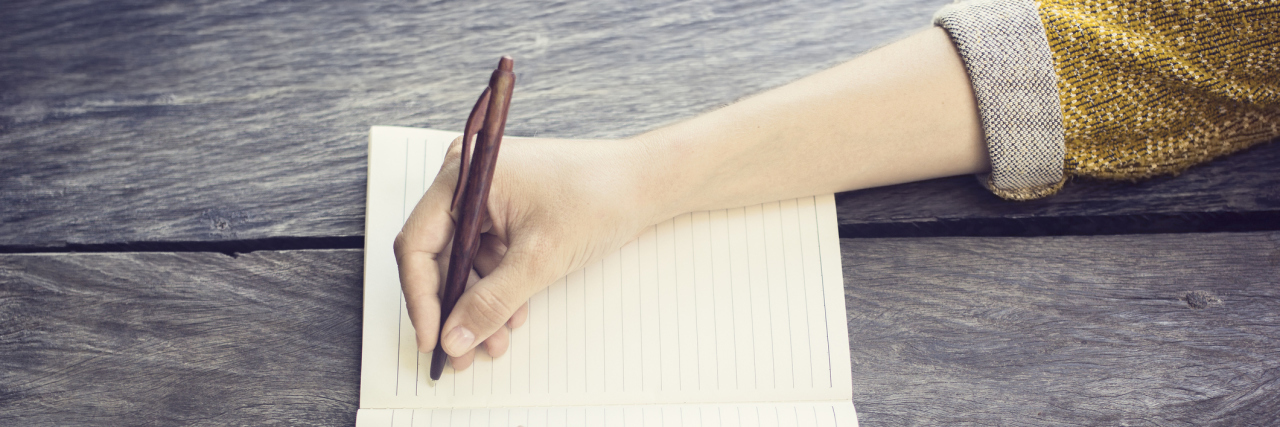 A Letter to My New Breast Cancer Friend, From a Two-Time Survivor Girl with pen and blank diary on wooden table