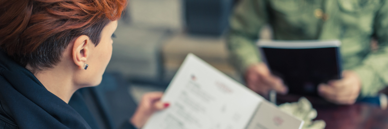 A young woman looking at a menu.