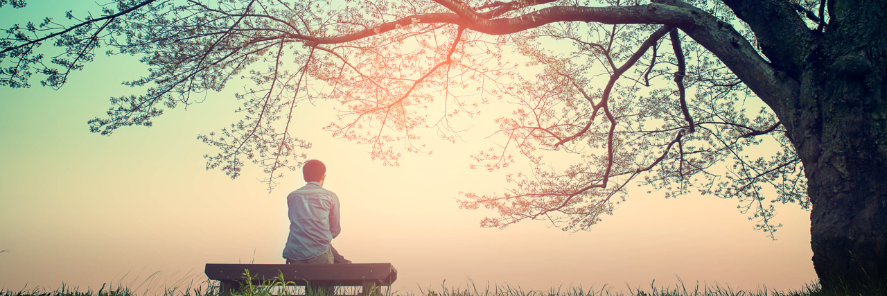 My Cancerously Single Life Male teenager Sitting alone on a bench in the park under a tree .