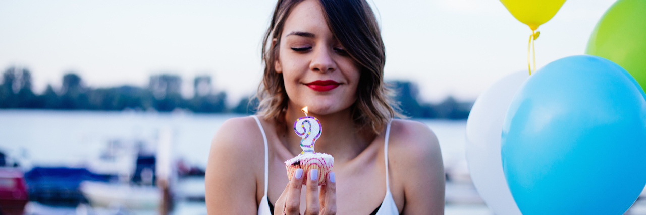 woman holding a cupcake with a candle