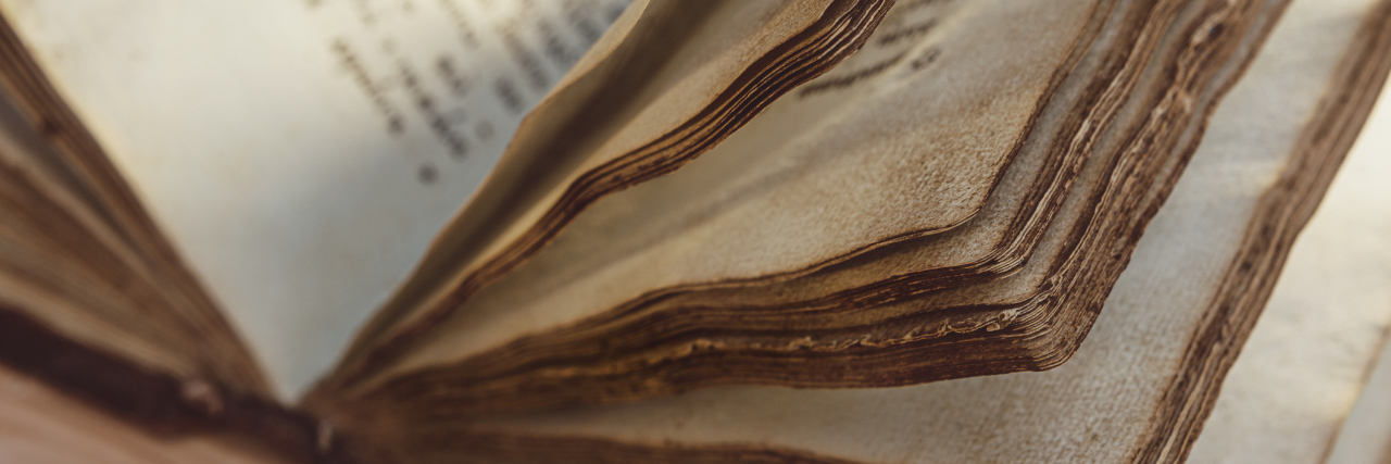 Introduction to Autistic History Month Old book with yellowed pages.