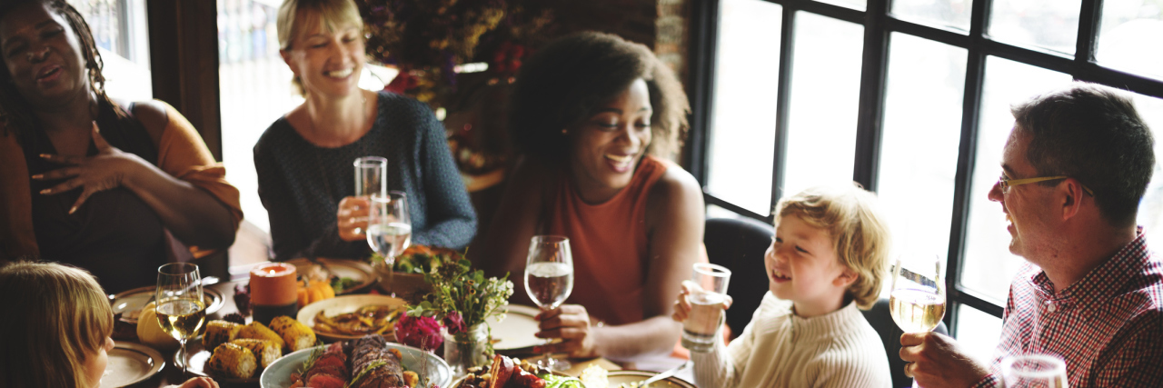 Managing the Stress of the Holidays With Chronic Illness people celebrating the holidays over dinner